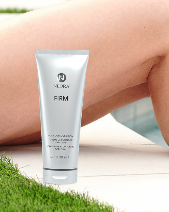 Woman sitting by the pool with Neora’s best-selling Firm Body Contour Cream